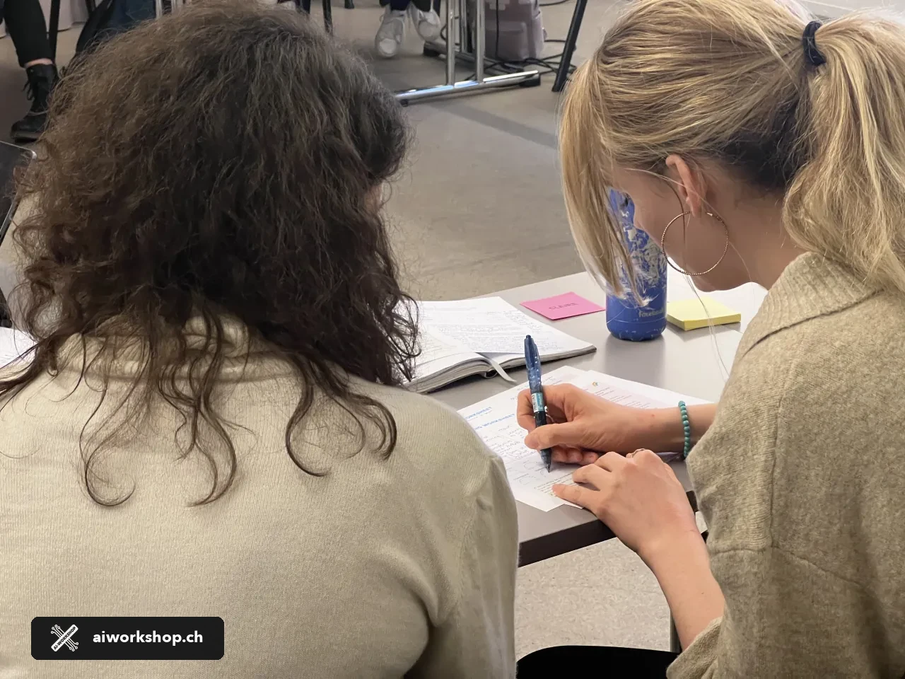 Two participants complete a hands-on AI for HR workshop exercise in Zürich